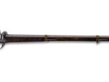 un vieux fusil avec un canon en bois et des garnitures en laiton