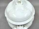 an image of a white tureeny dish with a lid on a table