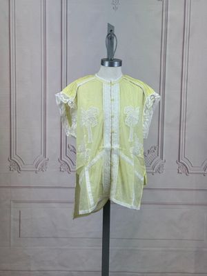 une photo d'une chemise jaune posée sur un mannequin devant un mur
