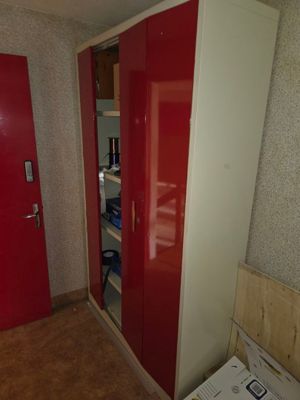 a red and white closet with a red door in a room