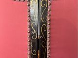a close up of the back of a pink chair with gold trim