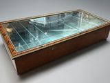 a glass display case with a clock on top of it