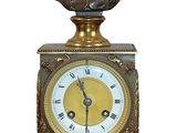 une horloge en bronze surmontée d'un buste