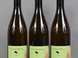 trois bouteilles de vin posées sur une table l'une à côté de l'autre