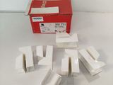 several pieces of white plastic are sitting on a table next to a red box