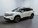 un SUV blanc garé dans une pièce au sol noir