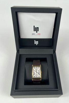 an open box with a watch inside of it on a white surface