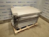une pile de draps blancs posée sur une palette devant un mur