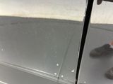 a person standing in front of a silver car