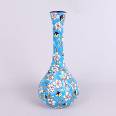 un vase bleu avec des fleurs posé sur une table
