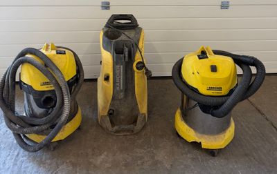 three vacuum cleaners are lined up in front of a garage door