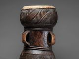 a wooden stool with a carved design on the top of it