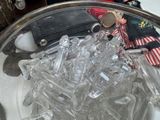 a glass bowl filled with plastic bottles and a doll on top of it