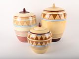 trois pots en céramique ornés de motifs géométriques sur un fond blanc