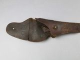 an old pair of brown leather holsters on a white surface
