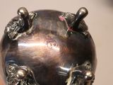 someone is holding a metal object in their hand that is shaped like a globe
