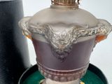 a silver vase with a crown on it sitting on a green tray