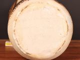 a white vase sitting on top of a wooden table