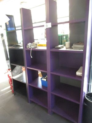 une bibliothèque violette dans un coin de la pièce