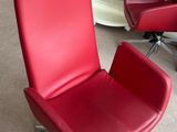 une chaise de bureau rouge posée au milieu d'une pièce