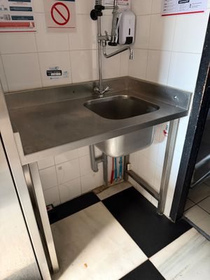 a stainless steel sink in the corner of a kitchen