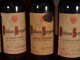 three bottles of red wine are lined up on a table