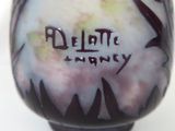 a purple vase with writing on it sitting on a table