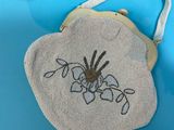 a purse with a picture of a spider on it on a blue surface