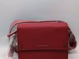 un sac à main rouge auquel est attaché un sac en plastique transparent