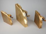 three pieces of gold that are sitting on a table