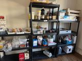 a black shelving with lots of food and supplies on it