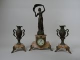 three bronze statues of a woman holding a fan and a clock