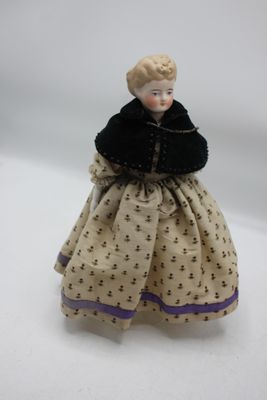 une image représentant une poupée à l'effigie d'une femme vêtue d'une robe et d'une fourrure