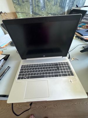 un ordinateur portable posé sur un bureau devant une fenêtre