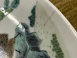 a plate with a picture of a woman and a hedge on it