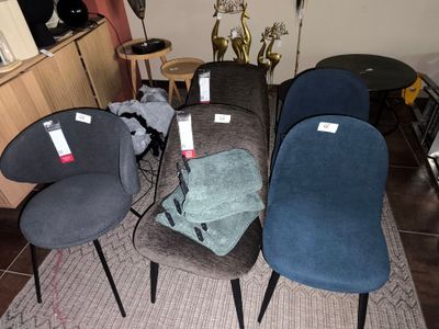 quatre chaises posées sur un tapis dans une pièce