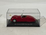an old model of a red sports car in a clear display case