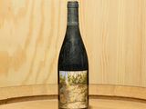 une bouteille de vin posée sur un tonneau