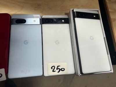 Trois téléphones Google Pixel sont posés les uns à côté des autres sur une table