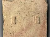 an old brick with a small imprint on it