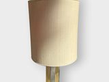 a close up of a lamp on a wall with a beige shade