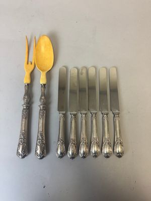 cinq fourchettes, une cuillère et un couteau sur une table