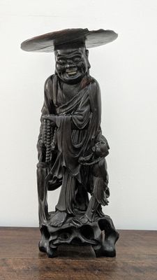 statue of a man with a hat on his head holding a cane