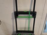 a black and green hand truck that is in front of a window