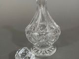 a clear glass vase and a small glass bottle on a table