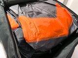 an orange and black bag with some clothes inside of it