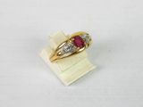 gros plan d'une bague en or avec une pierre en rubis