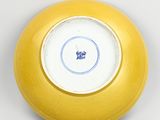 a yellow plate with a blue and white design on it