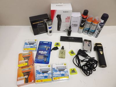 the contents of a shaver, razor, razor blade, and other items are laid out on a table