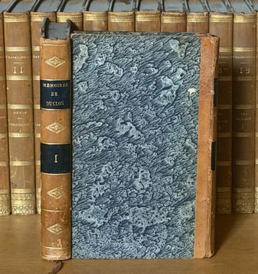 un livre posé sur une étagère à côté d'une pile de livres
